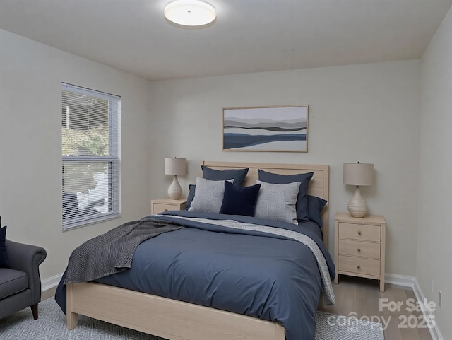 bedroom with baseboards and wood finished floors