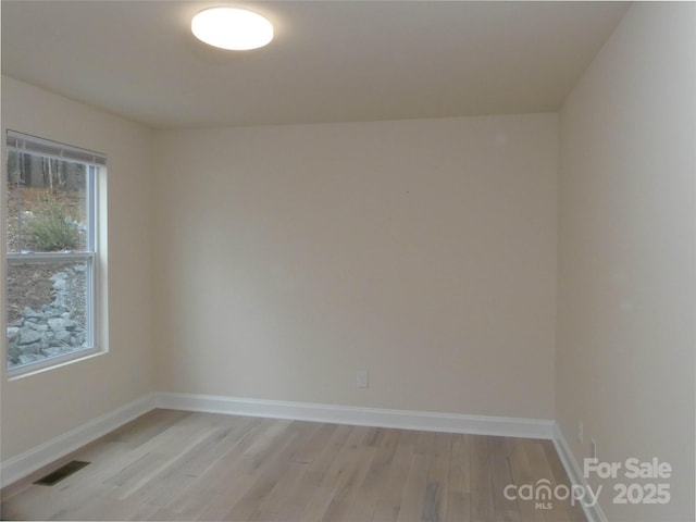 empty room with visible vents, baseboards, and light wood-style floors