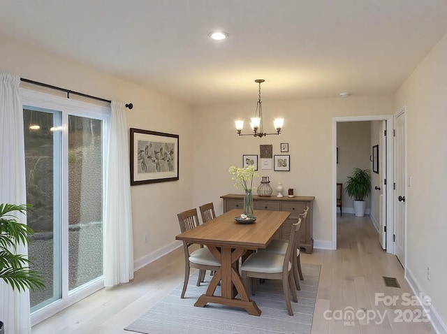 dining area with a notable chandelier, visible vents, baseboards, and light wood-style floors