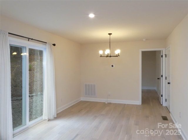 unfurnished dining area featuring baseboards, visible vents, light wood-style flooring, plenty of natural light, and a notable chandelier