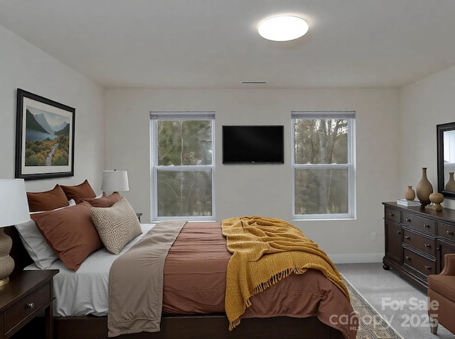 bedroom featuring baseboards, light carpet, and visible vents