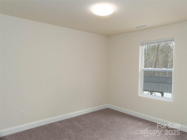 carpeted empty room featuring visible vents and baseboards