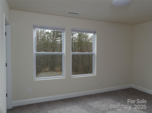 unfurnished room with visible vents, baseboards, and carpet