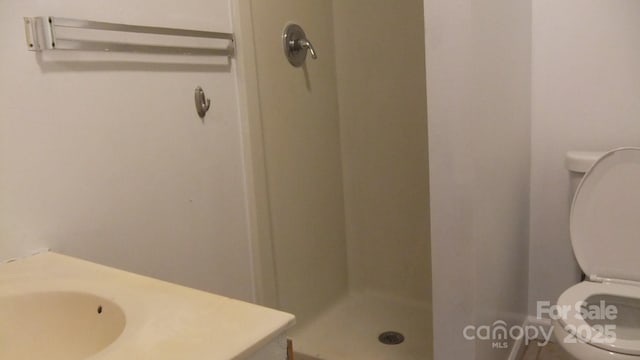 full bath with toilet, a stall shower, and vanity