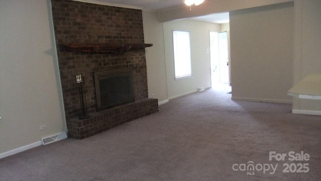 unfurnished living room featuring visible vents, a fireplace, baseboards, and carpet