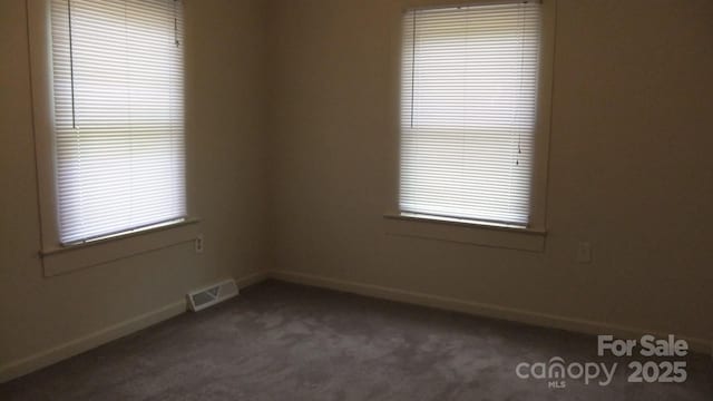 carpeted spare room with baseboards and visible vents