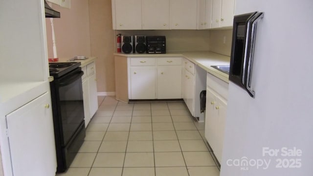 kitchen with extractor fan, light countertops, black electric range, light tile patterned flooring, and white cabinetry