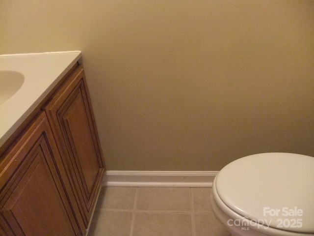 bathroom with vanity, toilet, baseboards, and tile patterned flooring