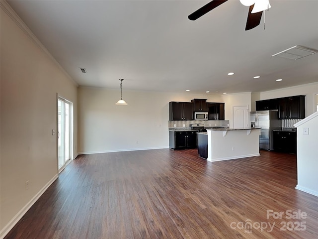 kitchen featuring stainless steel appliances, a kitchen bar, open floor plan, and decorative backsplash