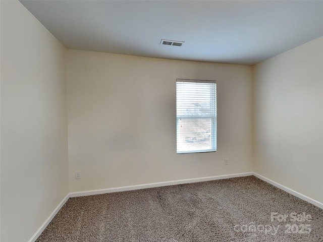 spare room with visible vents, baseboards, and carpet