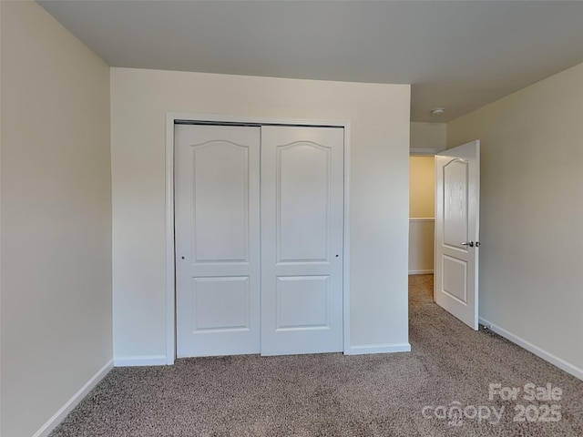 unfurnished bedroom featuring baseboards, a closet, and carpet floors