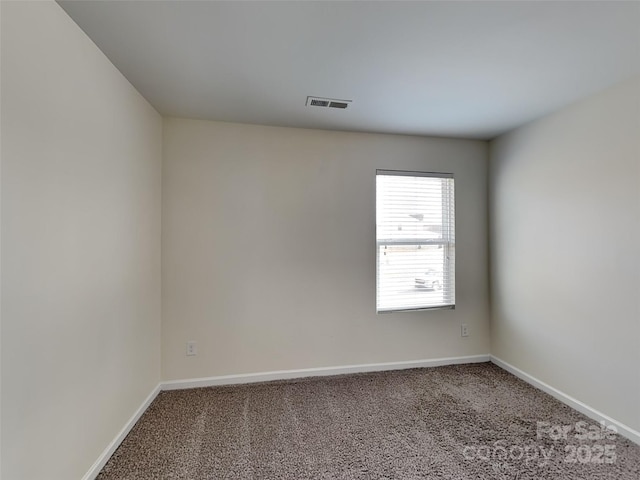 carpeted spare room featuring visible vents and baseboards