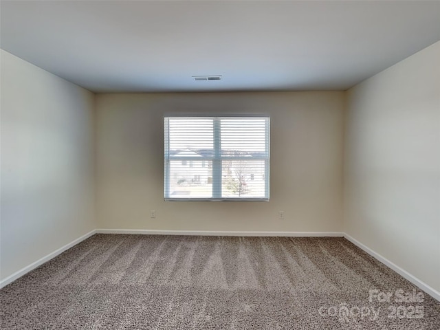 carpeted spare room featuring visible vents and baseboards