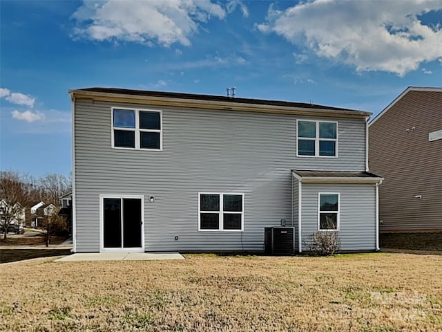 rear view of house featuring a patio, central AC unit, and a lawn