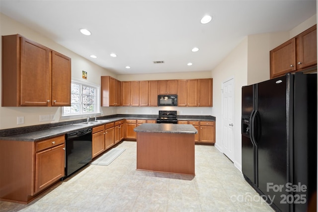 kitchen featuring black appliances, recessed lighting, dark countertops, and a kitchen island