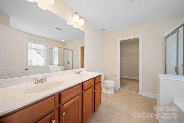 bathroom with double vanity, visible vents, a shower stall, and a sink