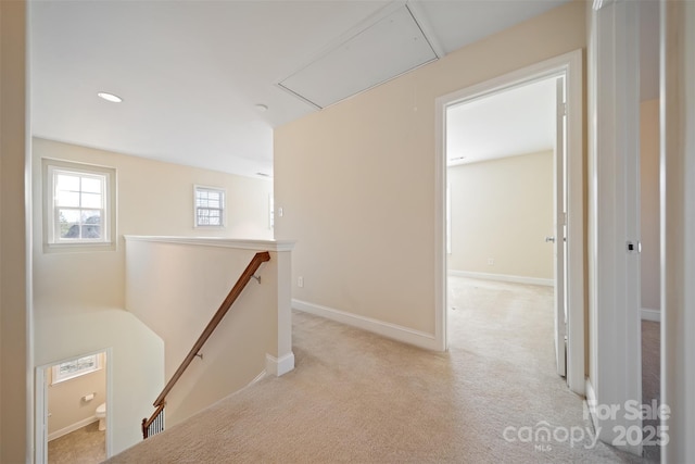 hallway with baseboards, attic access, an upstairs landing, light carpet, and recessed lighting