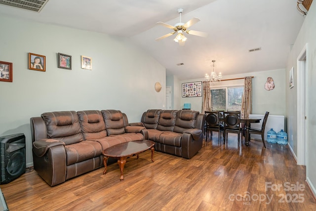 living area with wood finished floors, ceiling fan with notable chandelier, visible vents, and lofted ceiling