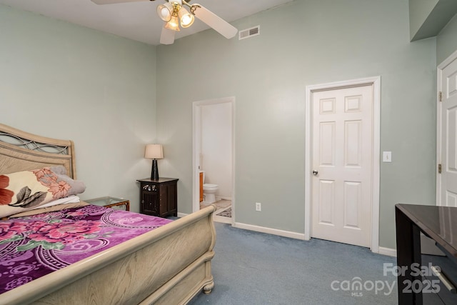 carpeted bedroom with ceiling fan, visible vents, baseboards, and ensuite bath