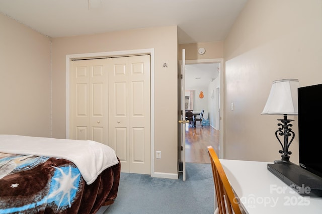 carpeted bedroom with baseboards and a closet