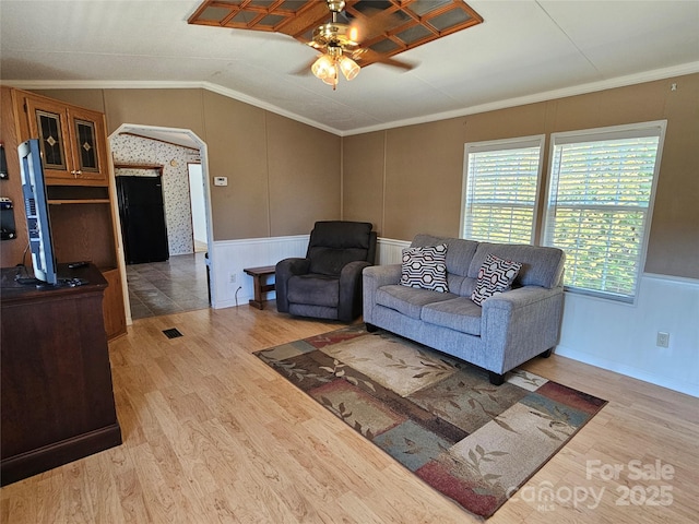 living room with ceiling fan, ornamental molding, lofted ceiling, and wood finished floors