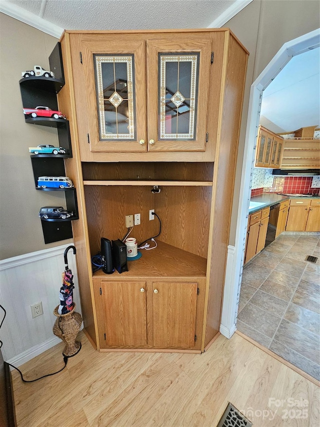 room details with a wainscoted wall, dishwasher, and wood finished floors