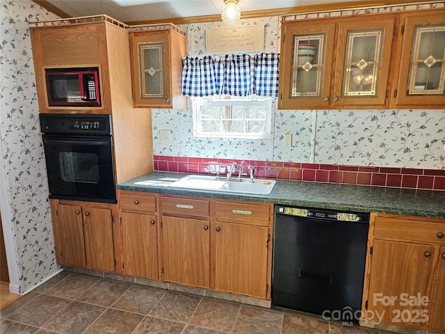 kitchen with wallpapered walls, black appliances, and a sink