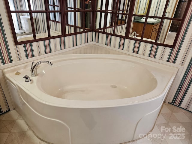 bathroom featuring wallpapered walls, tile patterned floors, and a garden tub