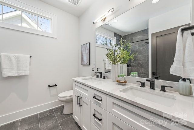 2021 S St, Charlotte, NC 28208 - full bathroom with double vanity, toilet, baseboards, tiled shower, and marble look tiles