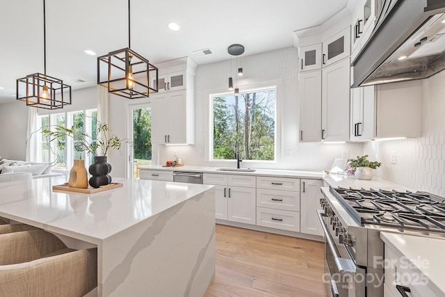2013 S St, Charlotte, NC 28208 - kitchen featuring stainless steel appliances, a sink, white cabinetry, under cabinet range hood, and a chandelier