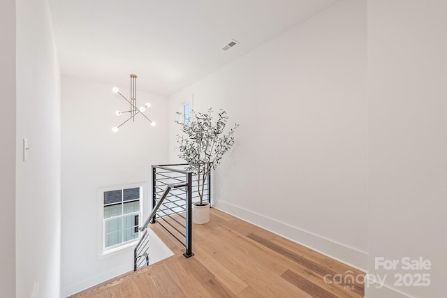2013 S St, Charlotte, NC 28208 - staircase with wood finished floors, a chandelier, and baseboards