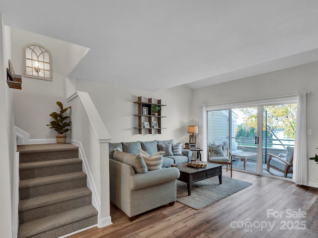 living area with light wood finished floors, stairway, and baseboards