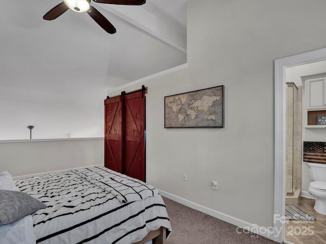 bedroom with ceiling fan, baseboards, a barn door, carpet flooring, and ensuite bathroom