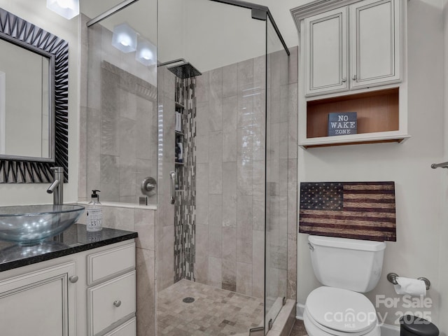 bathroom featuring a stall shower, toilet, and vanity