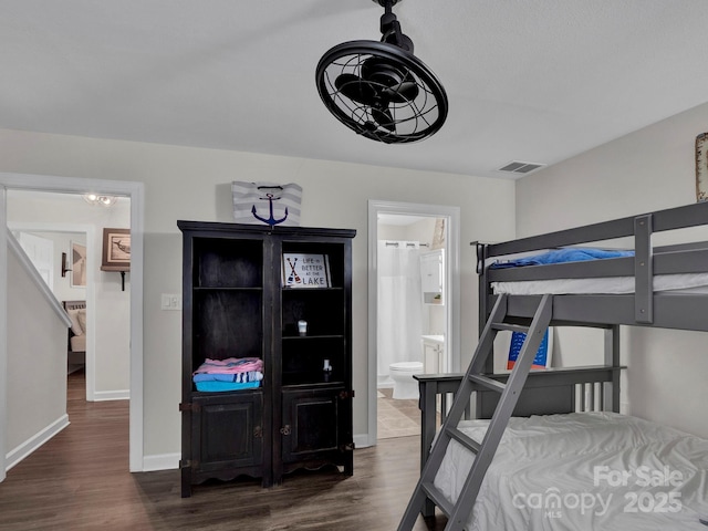 bedroom featuring visible vents, connected bathroom, baseboards, and dark wood-style flooring