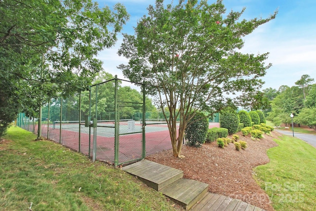 view of sport court featuring a lawn and fence