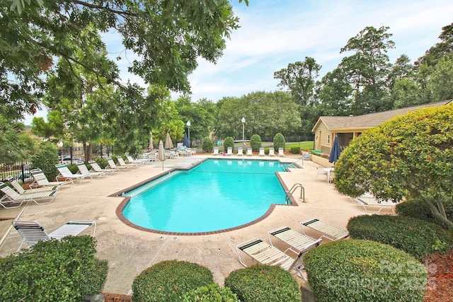 community pool featuring a patio and fence