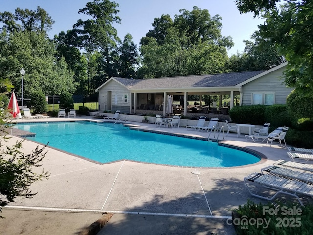 community pool featuring a patio and fence