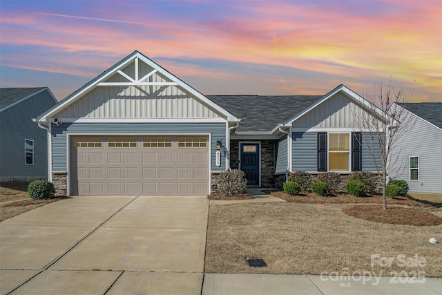 craftsman inspired home with a garage, stone siding, board and batten siding, and driveway