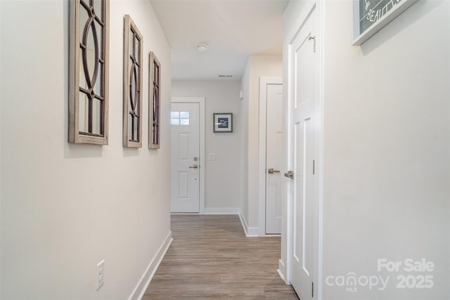 hallway with baseboards and wood finished floors