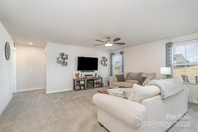 living room featuring a ceiling fan, light colored carpet, and baseboards