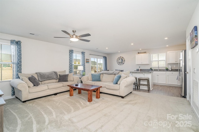 living room featuring recessed lighting, visible vents, light wood-style flooring, and a ceiling fan