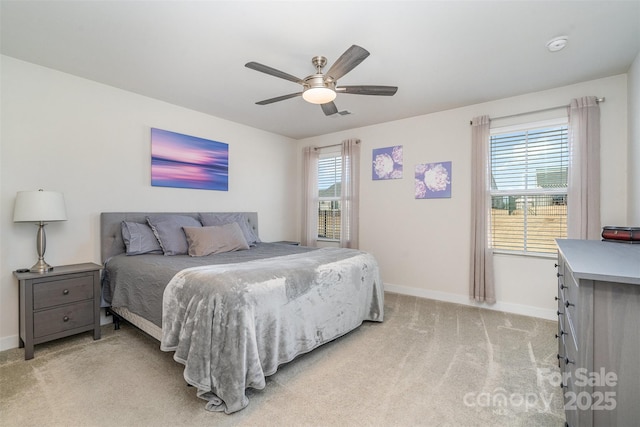 bedroom with ceiling fan, baseboards, and light carpet