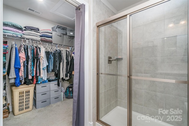 bathroom featuring a walk in closet, a shower stall, and visible vents