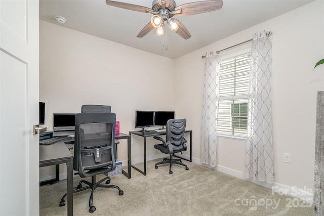 carpeted home office featuring baseboards and ceiling fan