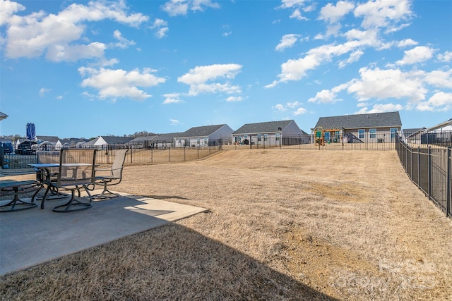 view of yard featuring a patio area, a residential view, and a fenced backyard