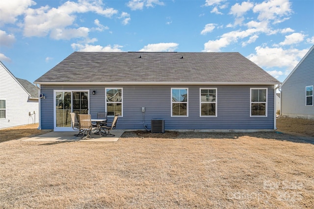 back of house with a patio area, a yard, and roof with shingles