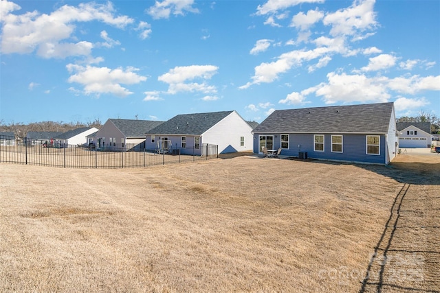 rear view of property featuring fence and a lawn