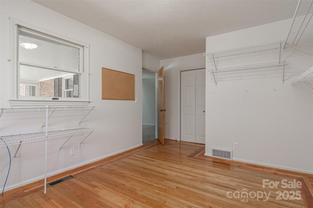 interior space featuring visible vents, baseboards, and wood finished floors