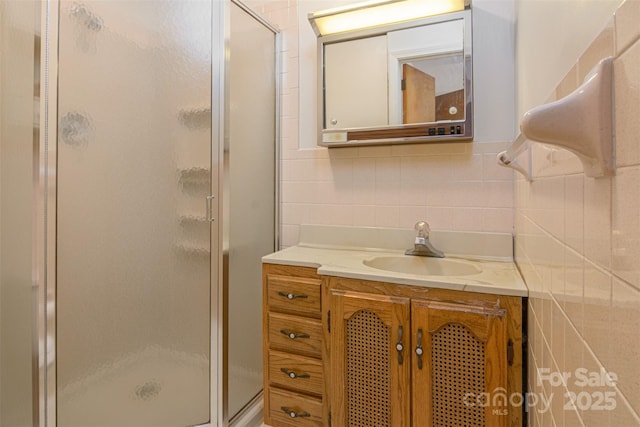 full bathroom with decorative backsplash, vanity, and a stall shower